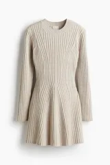 Vestido corto de punto acanalado con diseño entallado, cuello redondo y mangas largas con puños acampanados. Presenta una falda con leve vuelo y detalles de tejido menguado en el frente y la espalda.
