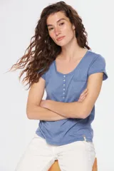 Remera color beige con escote redondo, manga corta, bolsillo en el pecho y cierre parcial con botones.