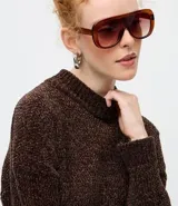 Suéter de punto texturizado con cuello alto, diseño oversized y mangas largas. Presenta una caída amplia y una superficie encorpada, ideal para un estilo moderno y acogedor.