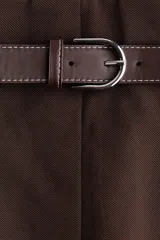 Pollera a la rodilla de tiro alto, de punto plisado color marrón, con elástico oculto en la cintura y cinturón incorporado de tejido revestido con hebilla metálica.