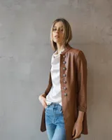 Tapado largo estilo blazer en color chocolate, con cuello mao y cierre frontal de botones metálicos decorativos. Presenta un corte estructurado y mangas tres cuartos.