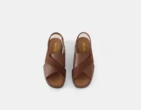 Sandalia de cuero color café con tiras cruzadas en el empeine, talón con elástico interno y plantilla acolchada. Tiene una plataforma ligera y un tacón de 3cm.