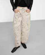 Pantalón barrel fit de denim de algodón orgánico y reciclado, con diseño estampado floral de trazos finos en tonos grises y oscuros sobre base beige. Presenta tiro medio, trabillas para cinturón, bolsillos y perneras redondeadas con costura lateral adelantada.