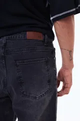 Pantalón de jean color negro con efecto lavado, de corte recto y ajuste cómodo.