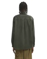 Camisa de manga larga Carhartt modelo Flint, confeccionada en pana de algodón color blanco. Presenta cuello clásico, cierre frontal con botones y un bolsillo en el pecho con el logo de la marca bordado.