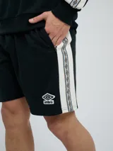 Bermuda de felpa azul marino con cordón ajustable en la cintura, bolsillos laterales y el logo de Umbro bordado en blanco en la pierna izquierda.