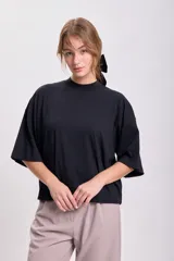 Remera negra de corte holgado, con cuello alto y mangas 3/4.