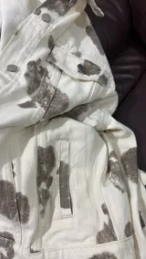 Campera de jean con corte oversize y estampado tipo animal print de manchas en tonos marrones sobre base color crema. Presenta cuello clásico, cierre frontal con botones metálicos, bolsillos con solapa en el pecho y puños abotonados.