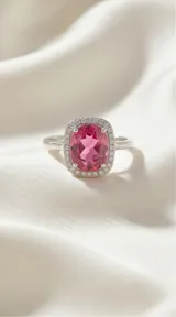 Anillo de plata 925 con diseño rectangular, protagonizado por una circonia ovalada central en color fucsia rodeada por un halo de pequeñas circonias brillantes.