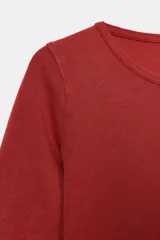 Camiseta de algodón color terracota con efecto lavado, cuello redondo y manga corta. Posee un bajo redondeado.