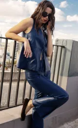 Pantalón de cuero ovino con corte flare, diseño de tiro alto y bolsillos traseros estilo jeanero. Presenta costuras verticales que estilizan la figura y tajos en el ruedo delantero.