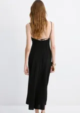 Vestido midi negro con tirantes finos, escote en pico y silueta evasé, confeccionado en mezcla de viscosa y poliamida.