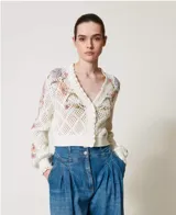 Cárdigan de punto calado color crema con estampa floral en tonos rosa y lila, escote en V y cierre frontal con botones.