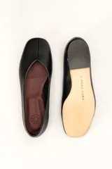 Chatas planas de cuero color plateado metálico, con punta cuadrada y un pequeño tacón bajo de madera.