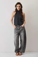 Blusa crop azul oscuro con cuello alto y diseño sin mangas, de tela con caída suave y ligero brillo.