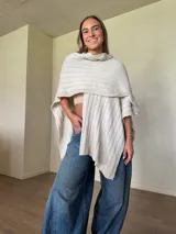 Ruana tejida de algodón con hilo lurex, con diseño holgado y caída asimétrica.