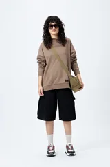 Canguro negro con capucha y bolsillo delantero. Presenta un bordado frontal y trasero con lettering “Mont Saint-Michel”.