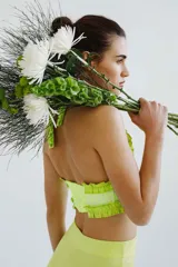 Top de escote halter confeccionado en broderie de algodón y bordado con hilo color coral. Enmarcado con voladitos de lino a tono.