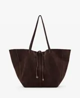 Bolso estilo shopper de piel de serraje color marrón oscuro, con cierre de lazo y botón magnético. Cuenta con doble asa de hombro y bolsillo interior con cremallera.