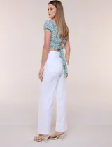 Top corto estampado con diseño floral en tonos azules y verdes sobre fondo blanco, con escote corazón fruncido con elástico, mangas cortas abullonadas y pretina ancha bajo el busto.