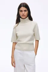 Top de punto suave con lana, de manga corta, con cuello alto acanalado y terminaciones acanaladas en puños y bajo.