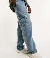 Pantalón de jean celeste, modelo baggy, con lavado dirty, efecto mármol y bolsillo cargo.
