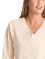 Blusa de algodón azul marino con bordado floral al tono. Presenta escote en V con terminación festoneada y mangas largas ligeramente abullonadas con puños abotonados. Su diseño es de silueta fluida y relajada.