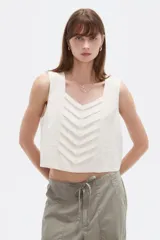 Musculosa sin mangas de color natural con cuello cuadrado y detalles de pliegues frontales en forma de chevrón.