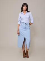 Falda midi de jean azul claro con corte en el centro del frente.