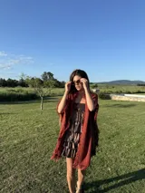 Chall de tejido liviano color rojo óxido con flecos en los bordes.