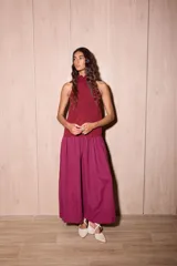 Vestido largo negro de crepe texturado con escote halter, cuello alto con volados y diseño holgado.