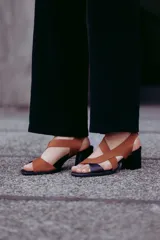Sandalias de cuero color marrón y negro, con tiras cruzadas y taco de 6 cm.