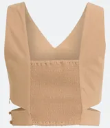 Blusa corta color beige con escote en pico y tirantes anchos. Presenta un recorte en la cintura.