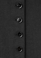 Chaleco de estilo sastre en color negro, con cuello redondo, cierre frontal de botones y diseño recto sin mangas.