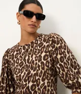 Blusa Marfinno de viscosa y lino con estampado animal print, cuello redondo, mangas tres cuartos abullonadas y cierre frontal oculto.