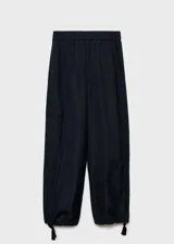 Pantalon de corte recto y tiro medio, confeccionado en tejido técnico de poliéster. Presenta cintura elástica, bolsillos laterales y bolsillos de parche con solapa en las piernas. El bajo cuenta con un sistema de fruncido regulable.