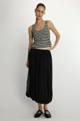 Top de punto sin mangas, color blanco y negro, con escote redondo y diseño a rayas horizontales.