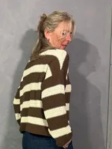 Sweater de punto a rayas horizontales en marrón y beige, con cuello redondo y mangas largas.