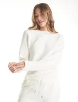 Buzo de punto acanalado horizontal en color beige, con escote a la base y diseño de manga japonesa que brinda una caída fluida y holgada.