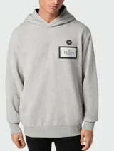 Buzo con capucha de algodón color gris melange, con diseño de manga larga y parche rectangular con logo de la marca en el pecho.
