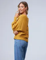 Buzo marca Cupio de tejido acanalado color azul. Tiene mangas largas estilo dolman y aplique de botones en la espalda.