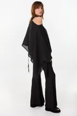 Blusa de lino italiano color negro, con diseño asimétrico de hombro descubierto y cuello tipo choker integrado, de manga larga amplia.