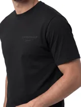 Remera negra Caterpillar de manga corta y cuello redondo, confeccionada en algodón con lavado enzimático. Cuenta con gráfico bordado en el pecho y parche con logo de la marca en la parte inferior.