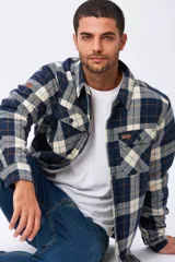 Campera tipo leñadora de viyela a cuadros, con interior forrado en corderito para mayor abrigo. Presenta cierre frontal con botones, cuello clásico y dos bolsillos frontales con solapa y botón.