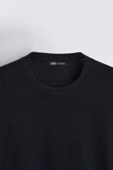 Jersey color crudo de tejido de punto, con cuello redondo y mangas largas. Corte amplio y terminaciones en rib.