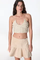 Top halter color beige de tejido de punto con lurex.