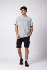 Bermuda cargo de gabardina con bolsillos laterales amplios con solapa y broche metálico. Presenta cintura con pasadores para cinturón y etiqueta tejida decorativa en uno de los bolsillos.