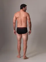 Pack de tres slips negros Calvin Klein de microfibra con cinturilla elástica con el logo de la marca en blanco, rosa y rojo. Confeccionados con un 88% de poliéster reciclado.