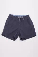 Short de baño azul marino con cintura elástica y cordón ajustable. Presenta un forro interno tipo suspensor, dos bolsillos laterales y un bolsillo trasero. Incluye un pequeño logo bordado en la parte inferior de la pierna derecha y un detalle estampado en el interior de la cintura.