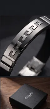 Pulsera masculina con placa central de acero inoxidable que presenta un diseño geométrico tipo greca, combinada con una banda de goma negra.